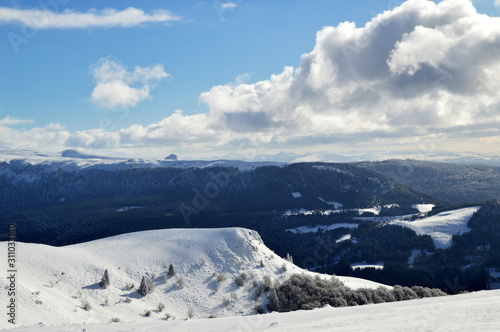 A beautiful viewpoint of the snowy volcanic mountain range during the winter  in Auvergne.