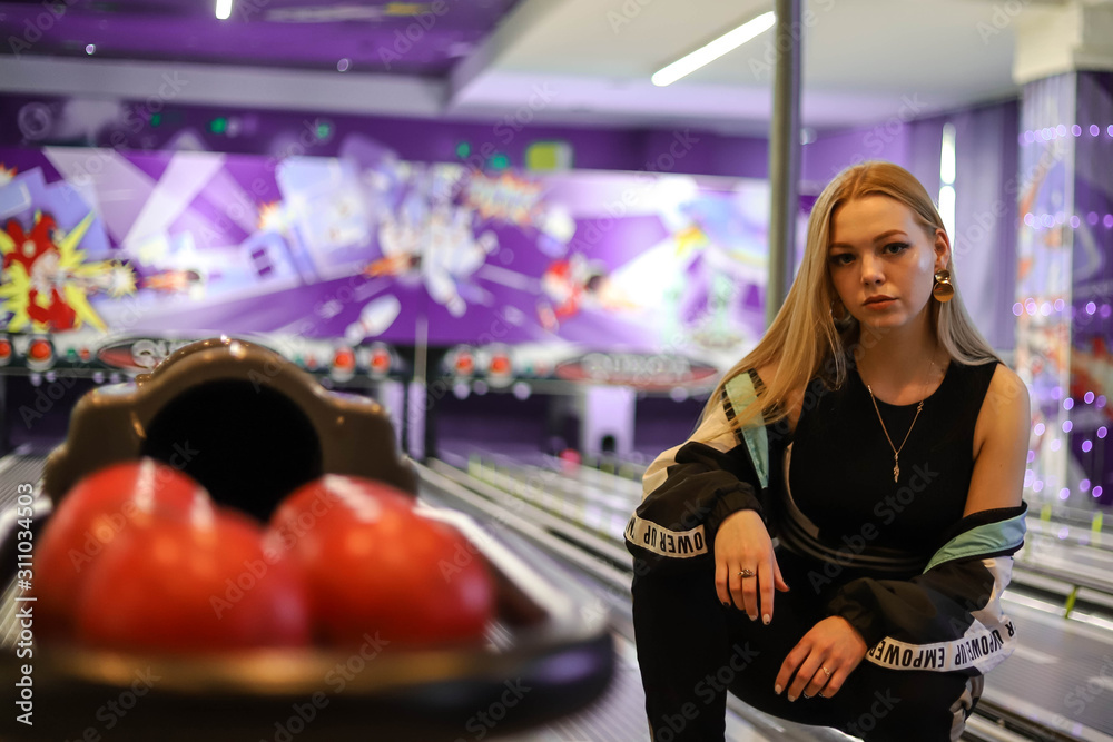 Young beautiful girl on bowling alley