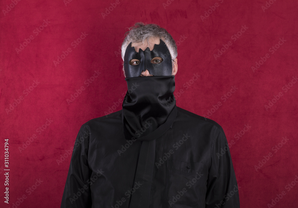 man in bat mask on a red background man in bat mask on a red background
