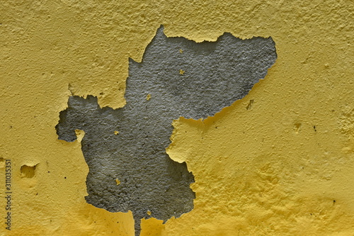 Background texture of old cement wall with yellow paint peeling off.