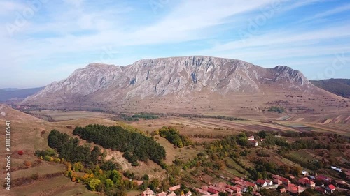 Forward aerial shot of Rimetea and mount Szekelyko, on a sunny autumn day photo