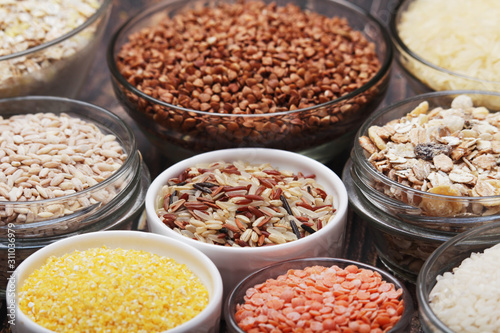 A set of bowls filled with different seeds: buckwheat, rise, corn and oatmeal 