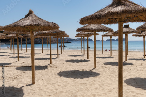 Parasols on the beach of Paguera in Calviá. Island of Mallorca. Spain.