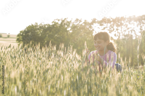 Little girl in the spikelets field.