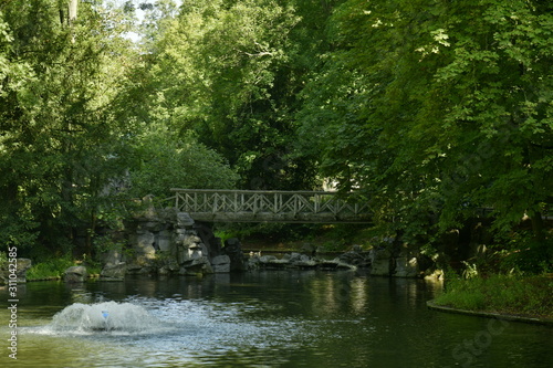 Le pont rustique en rocaille sous la végétation très dense au parc Josaphat à Schaerbeek