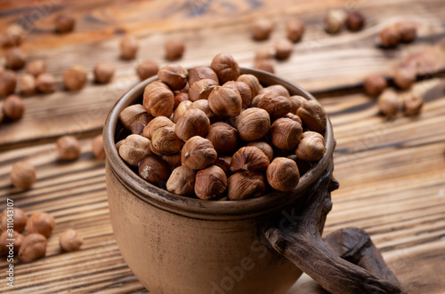 hazelnuts in a decorative cup on wooden boards close-up