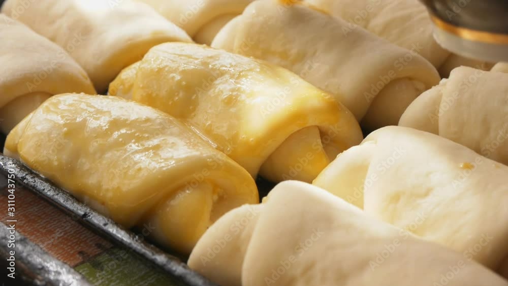 Spreading buns with eggs before baking Spreading buns with eggs before baking