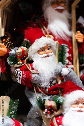 Merry Christmas and Happy new Year , Santa Claus doll with girts in Christmas festival , Copy space. Cute grandfather frost in red costume and gray gloves on tree background. gift and celebration.