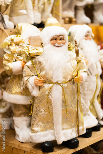 Merry Christmas and Happy new Year , Santa Claus doll in Christmas festival , Copy space. Cute grandfather frost in golden costume on tree background. gift and celebration.