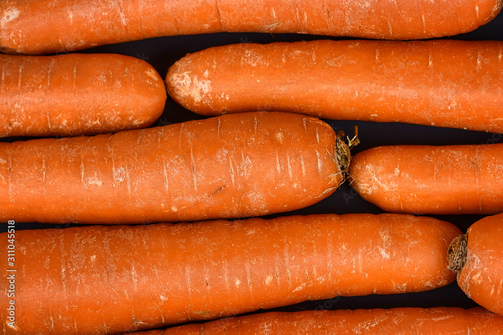 Top view of raw fresh carrots on dark background Top view of raw fresh carrots on dark background