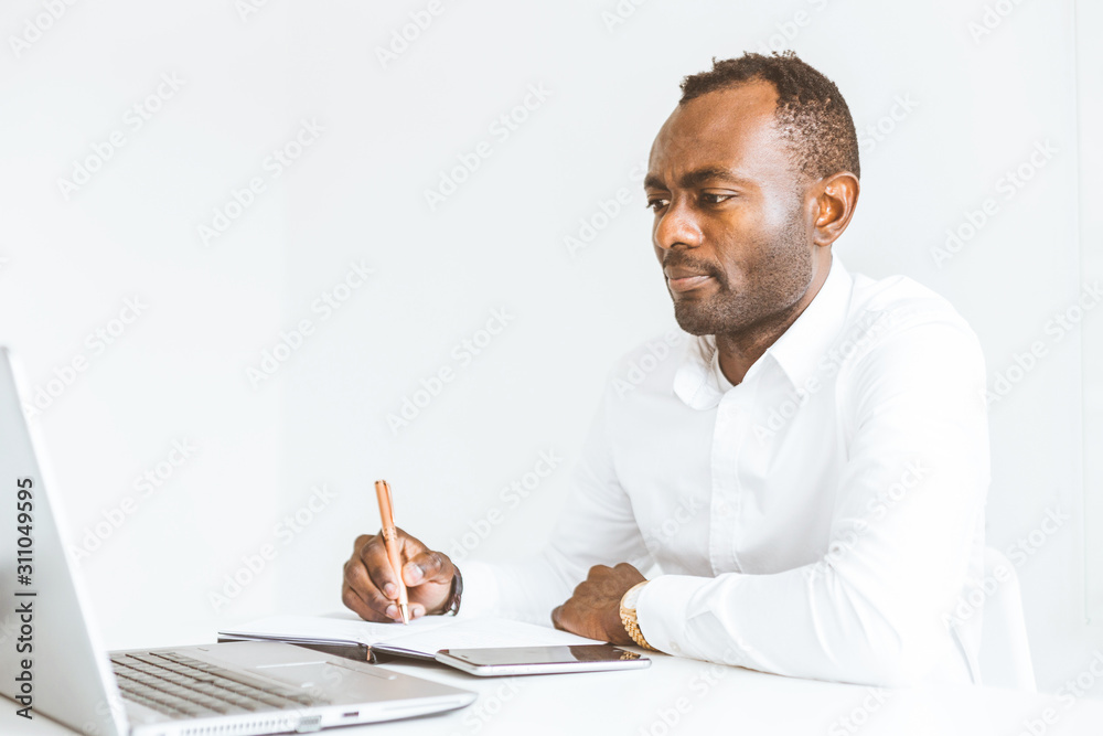 Young african American businessman working in the office at the laptop Young african American businessman working in the office at the laptop