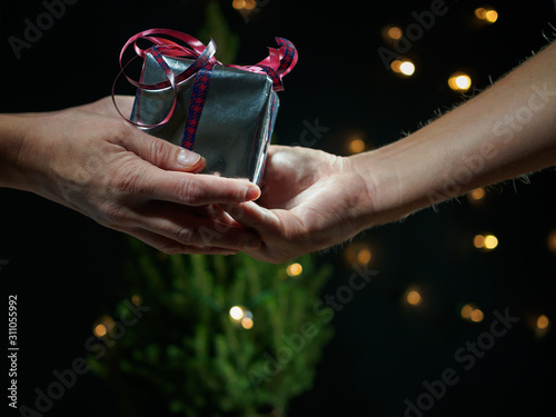 A man gives a woman a gift for Christmas
