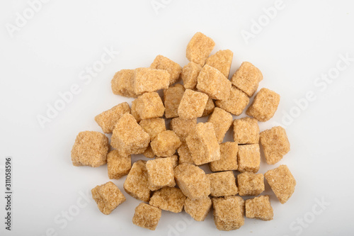 A bunch of brown sugar pieces on a white background top view.