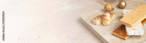 Traditional Spanish Christmas sweets turron, almond nougat and marzipan on large wooden background for banner with copy space.