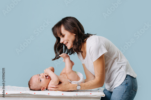 mother bent over her infant talking, caring and playing with him
