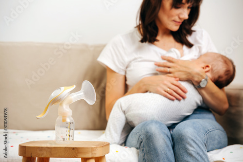 Mom gently looks at the baby and breastfeeds