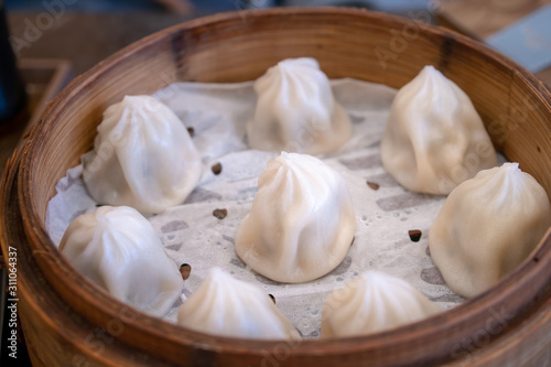 Selective focus of Chinese steamed bun or Xiaolongbao on bamboo steaming basket.
