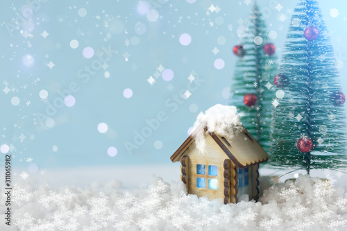 the concept of new year and Christmas. wooden house on a blue background with Christmas trees. © Vera