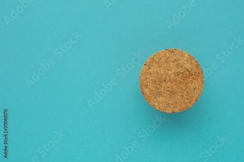 Eco friendly minimalist background. Top view at cork stopper on bright blue paper backdrop. Natural eco lifestyle.