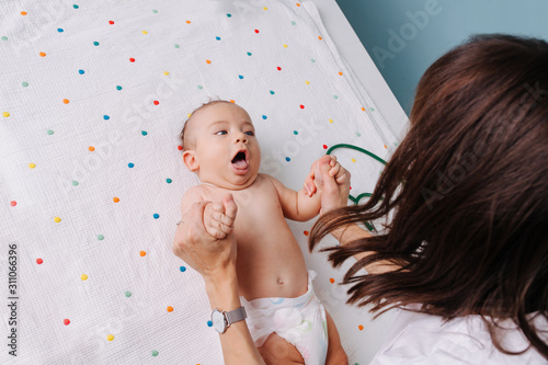 pediatrician doctor checks the baby's grasping reflexes