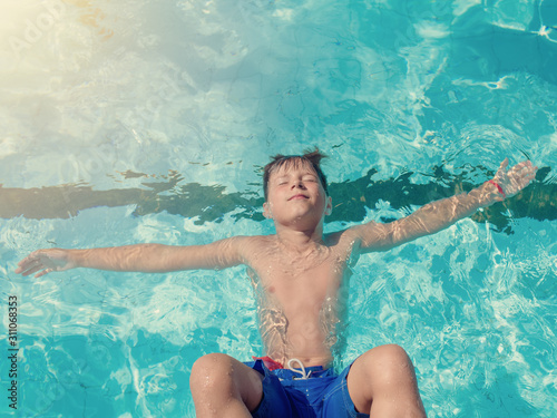 Quadro em tela European boy relaxing in swimming pool keeping eyes closed and hands wide open