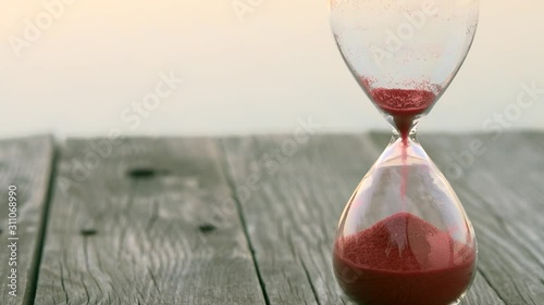 Hourglass with red sand counts minutes.