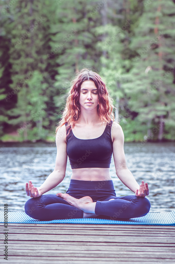 Beautiful girl in a yoga pose on the lake. Lotus position , Padmasana. The concept of appeasement, healthy lifestyle. Beautiful girl in a yoga pose on the lake. Lotus position , Padmasana. The concept of appeasement, healthy lifestyle.