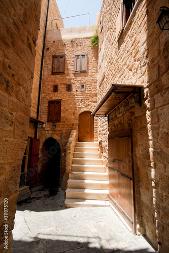 Old street with sandstone arc and wooden closed doors in downtown of Saida, Lebanon
