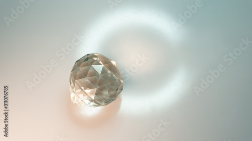 Large crystal on a white background with light refraction abstraction. A lot of space for an inscription or logo.