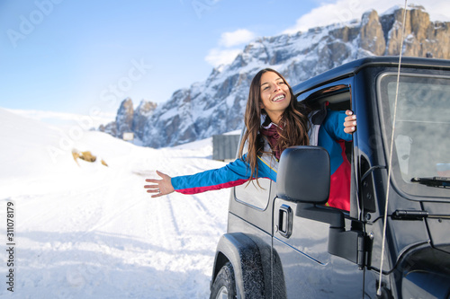 Woman looking out of the car's window to enjoy the mountain's view