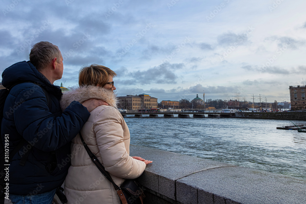 Man and woman in a good mood, looking at the sea and the city. A beautiful evening in Europ