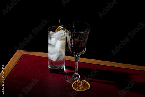 Vermouth and gin tonic, a long drink with gin and tonic water, granished with charred orange photo