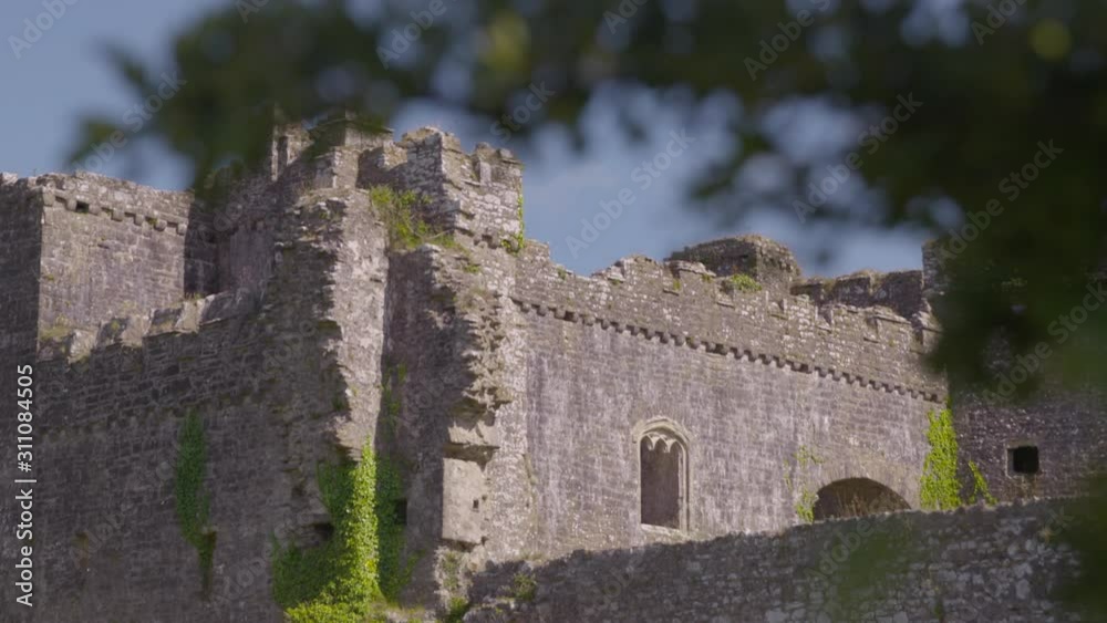 A racking focus of a tree branch then zooming onto the corner of an old castle on a sunny day A racking focus of a tree branch then zooming onto the corner of an old castle on a sunny day