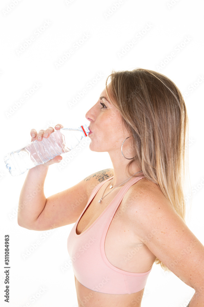 Sporty muscular slim woman 30 drinking water against white background Sporty muscular slim woman 30 drinking water against white background