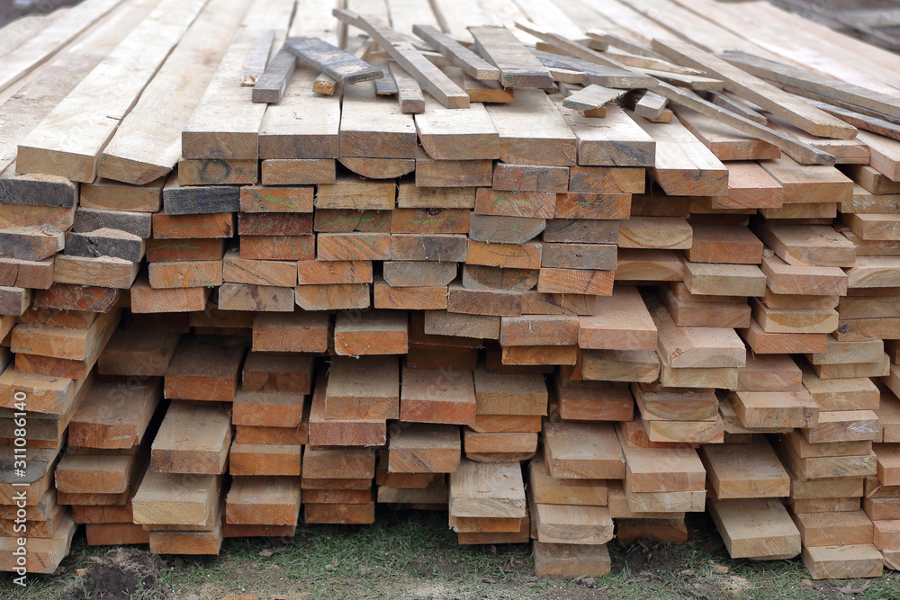 Heap of long wooden boards for the construction and improvement of the yard