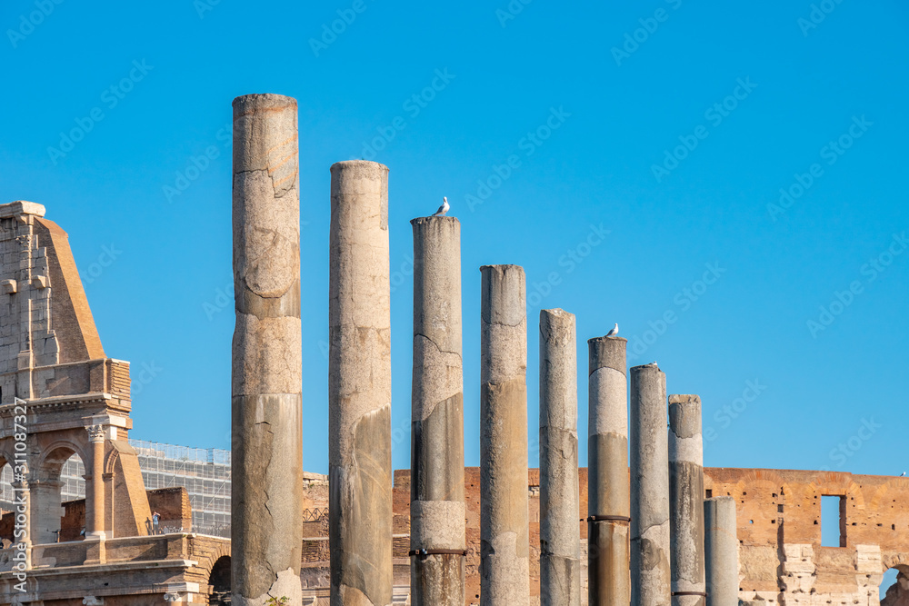 antique columns against the blue sky, the historical part of the city of Rome.