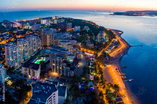 Evening panorama of the seaside resort of Gelendzhik. View of the Thick Cape and lighthouse. See the beach and the promenade. On the left is a large residential complex