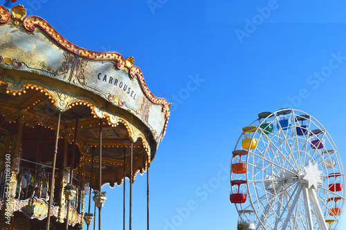 Carousel and Ferris wheel against the sky