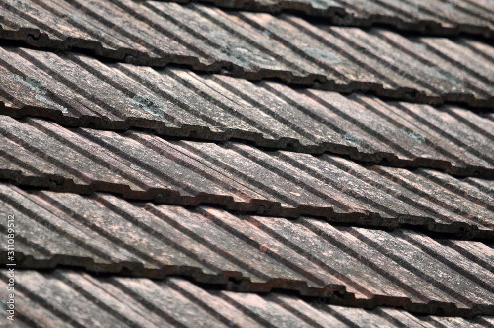 On the roof of the house is an old red tile On the roof of the house is an old red tile
