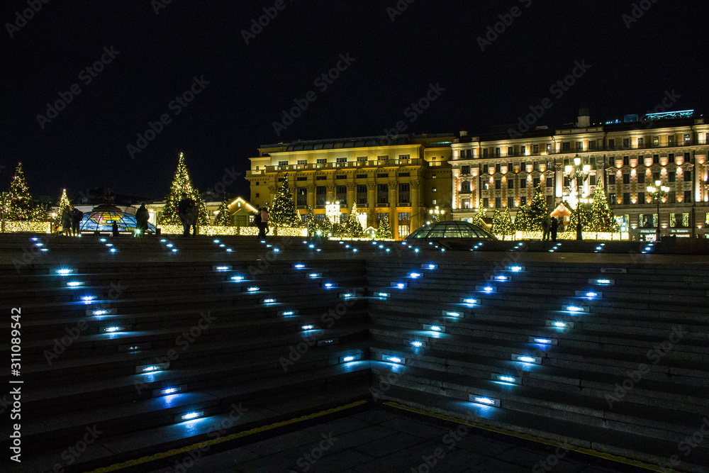 illuminated staircase on Okhotny Ryad against the black sky and historical buildings in Moscow Russia