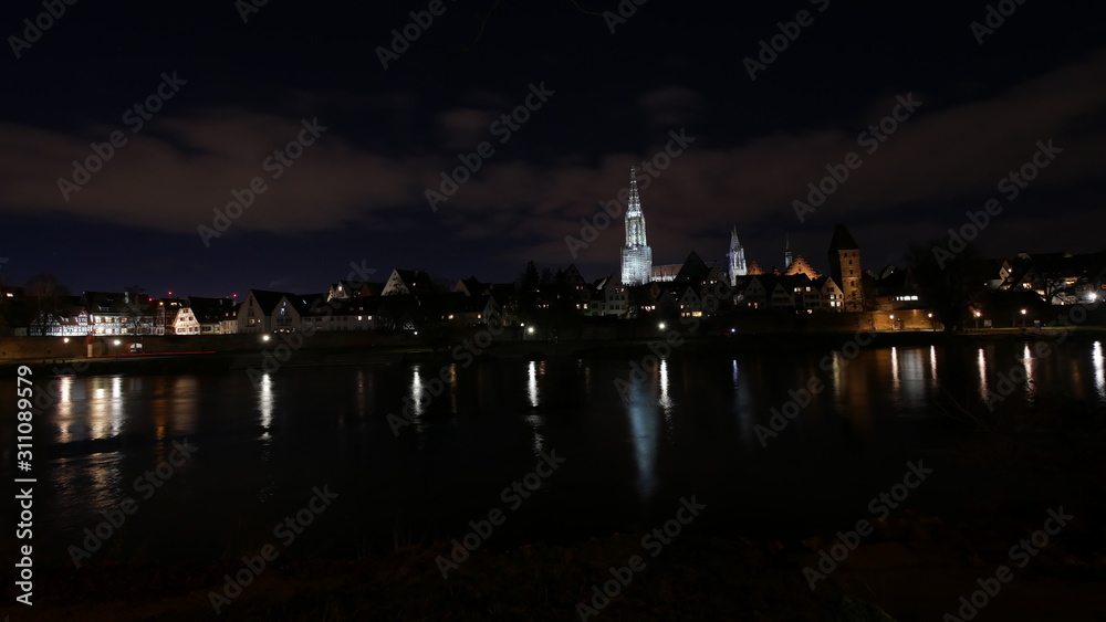 Ulm, Deutschland: Nächtliche Skyline mit dem Ulmer Münster hinter der Donau