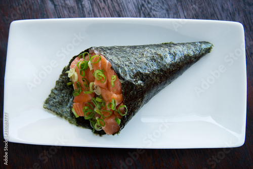 Canvas Print temaki cone-shaped sushi with raw salmon, top view, dark background, wooden back