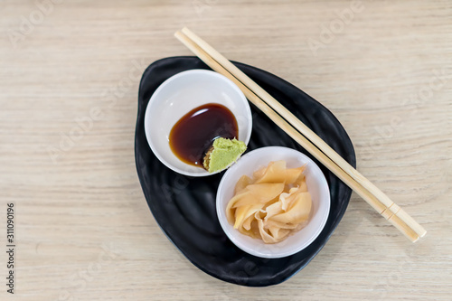 Ginger and wasabi on plate. traditional Japanese condiments - wasabi, ginger and soy sauce - a set for sushi on table. Pickled ginger with soy sauce and wasabi for sushi.