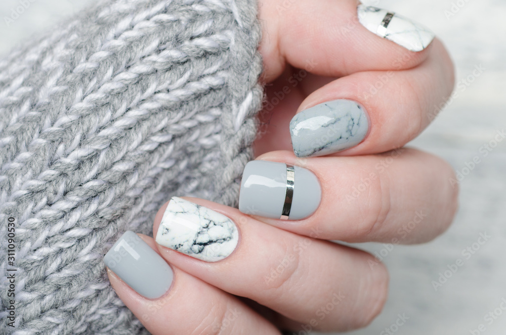 Fototapeta premium white grey marble manicure with silver stripe on grey background