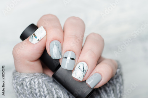 white and grey marble manicure with silver stripe on grey background