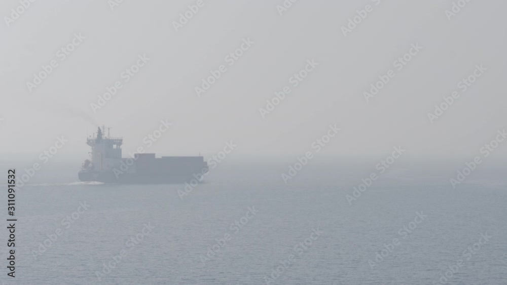 Container ship retires to the sea in fog Container ship retires to the sea in fog