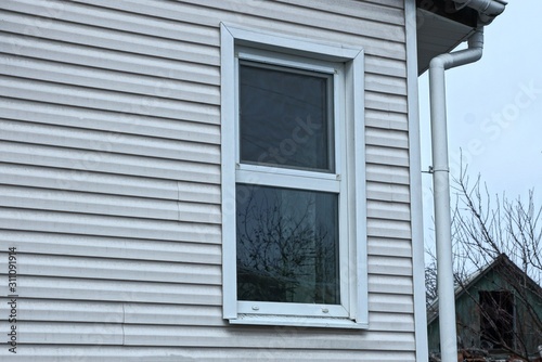one white window on the gray plastic wall of a private house