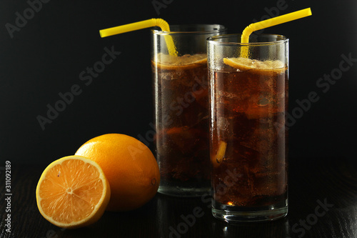 Glasses with cuba libre cocktail or cola with ice or cold tea with lemon	