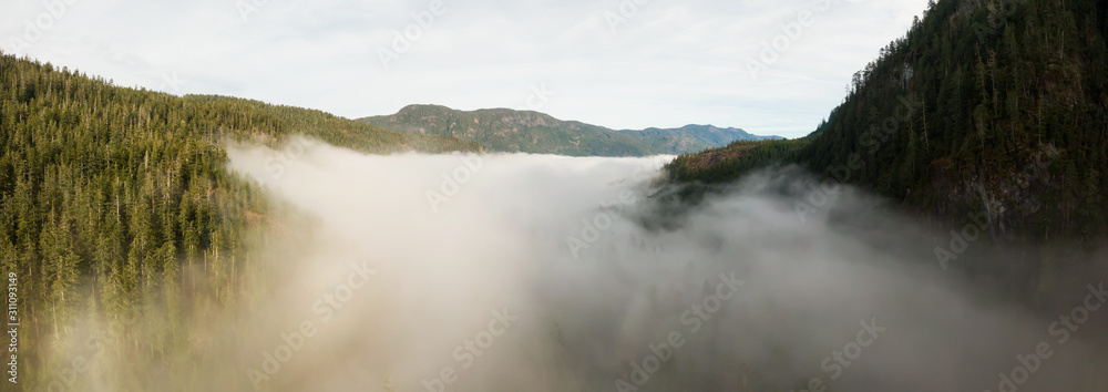 Aerial Panoramic View of Beautiful Canadian Mountain Landscape above the clouds during a sunny day. Located on the West Coast of Vancouver Island near Tofino and Ucluelet, British Columbia, Canada.