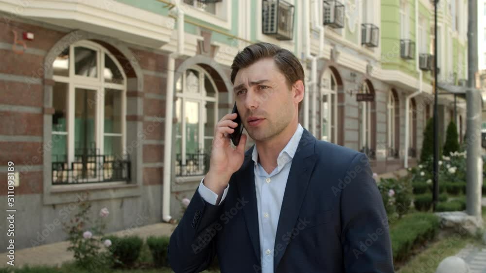 Closeup businessman talking phone outdoor. Male entrepreneur walking Closeup businessman talking phone outdoor. Male entrepreneur walking
